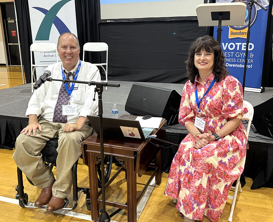 a man and a woman sit in front of a stage