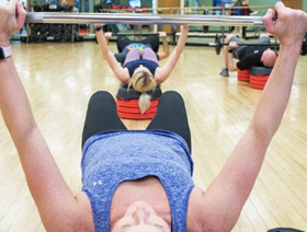 people lifting weights in a class