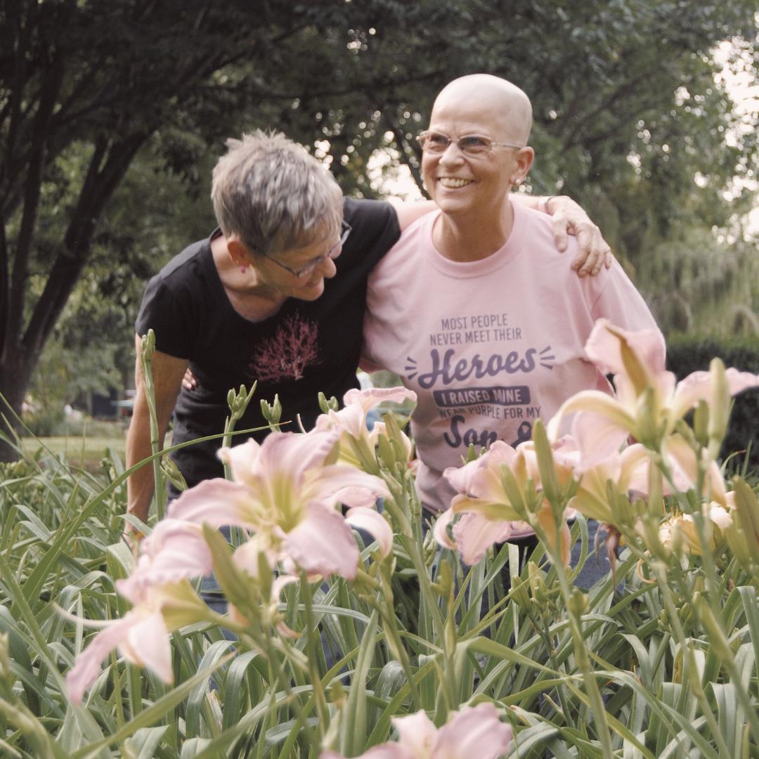 two people laughing in a field of flowers