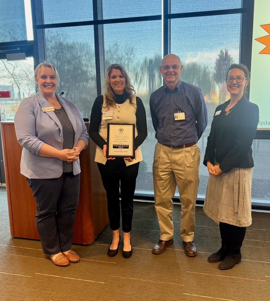 four people pose with an award