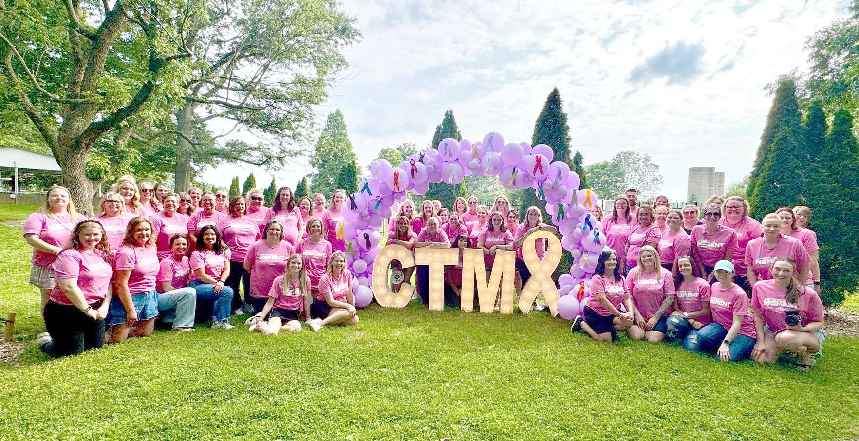 group of 100 people wearing pink outside