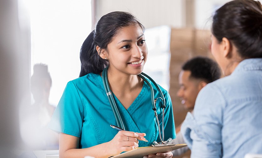 Female Resident Physician talks with a patient