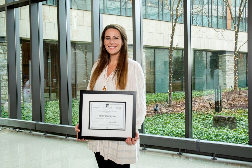 Emily Thompson holding her award