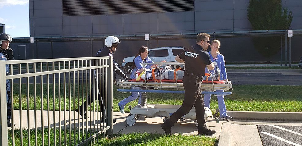 simulated patient wheeled on sidewalk