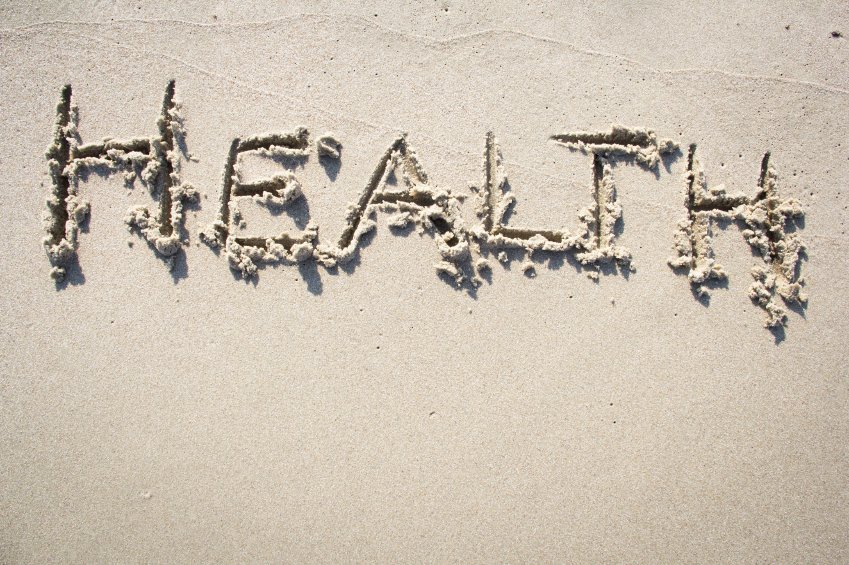 the word healthy written in sand