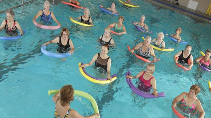 Ladies in the pool with swim noodles