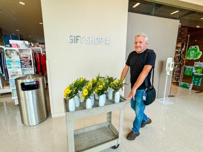 man pushes a cart of flowers in the hospital hall