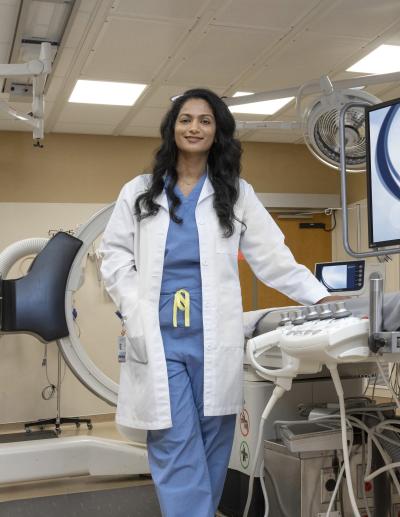 a brunette female surgeon stands in a procedure room