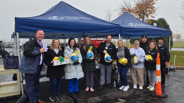 group of team members holding turkeys