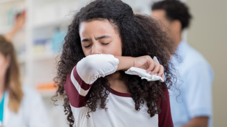 student coughing in a classroom
